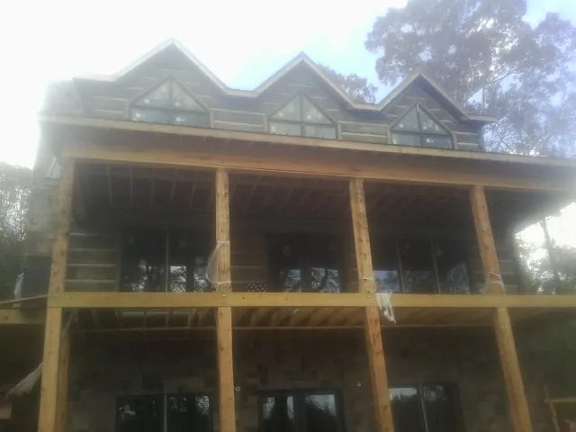 Dormers and porch framing on a large log home under construction — Roof Coating work by our crew in Bradley